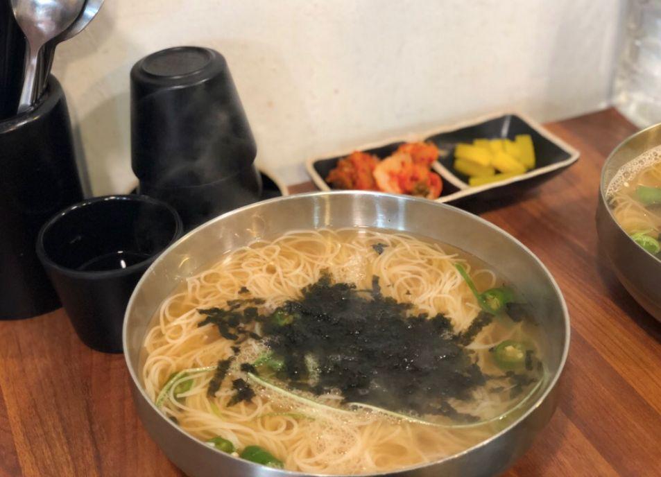 熱騰騰的宴會麵以濃鬱的鯷魚湯頭為基底，展現出韓國麵食在布帳馬車中的獨特風味及溫馨感。